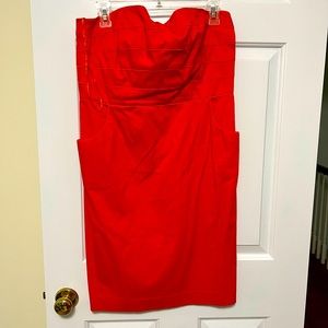 Coral colored strapless dress with piping detail across bust.